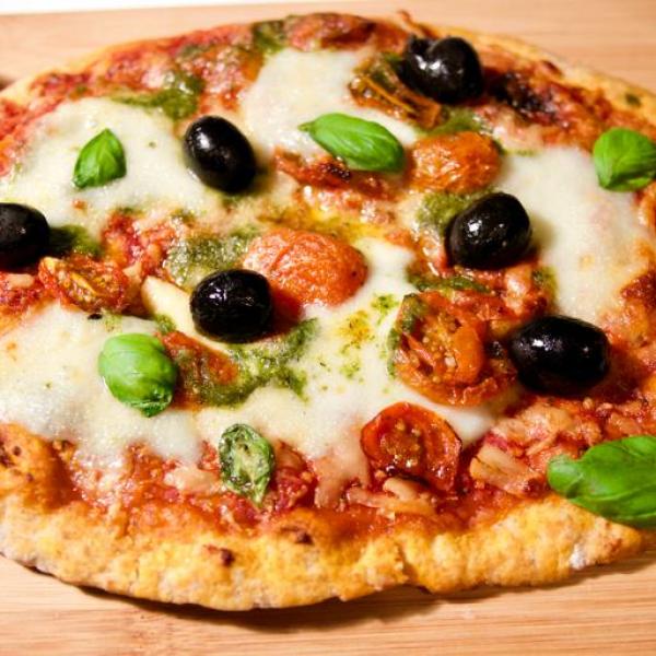 Olives, basil, and mozzarella top a gluten free pizza crust with marinara sauce